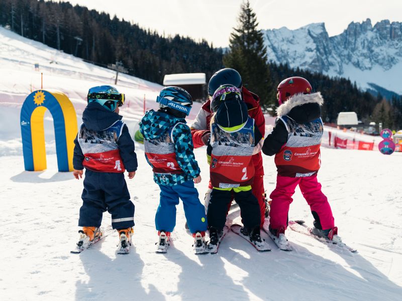 Kinder lernen in Carezza Skifahren