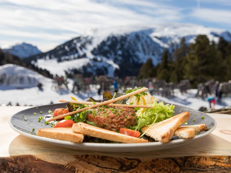 Salatteller mit Fleischpflanzerl vor Bergkulisse