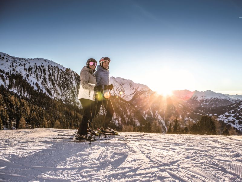 zwei Skifahrer vor Panorama Hochzeiger