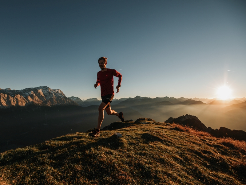 Trailrunner allein am Berg bei Sonnenaufgang